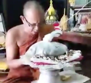 Pra Ajarn Gorp Chai chanting Thai Kata Akom blessing his original hand made amulets at Wat Mae Ya temple in Tak Province.